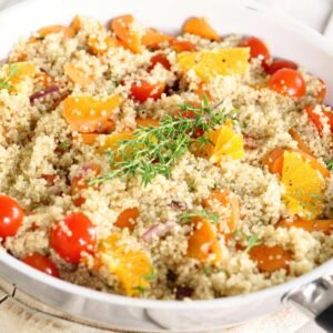 Delicious vegan quinoa salad with tomatoes, oranges, and fresh herbs.