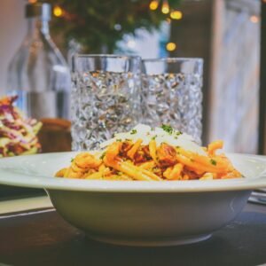 A cozy dinner setting with Italian pasta and fresh salad, perfect for a delightful evening meal.