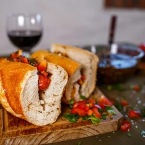 Close-up of a tasty choripán sandwich served with wine, highlighting Argentinian flavors.
